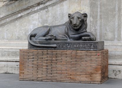 Фигура льва во дворе сосновой шишки