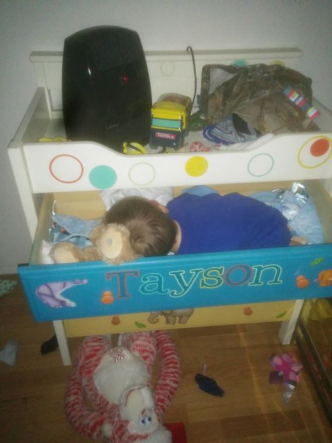Мальчик спит в ящике комода
