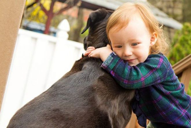 Ребенок обнимает собаку