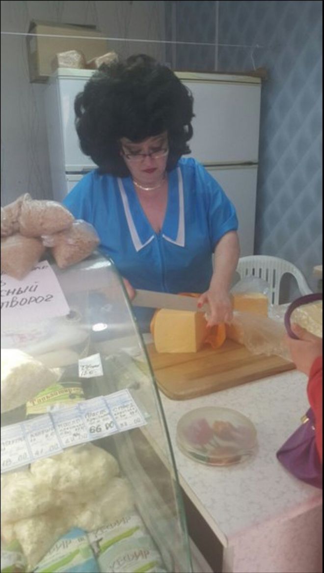 Продавщица режет сыр