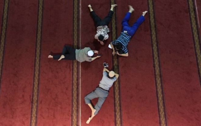 Мужчины отдыхают прямо на полу после пятничных молитв