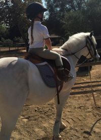 Малышка занимается конным спортом