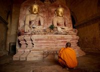 Монах перед статуями Будды