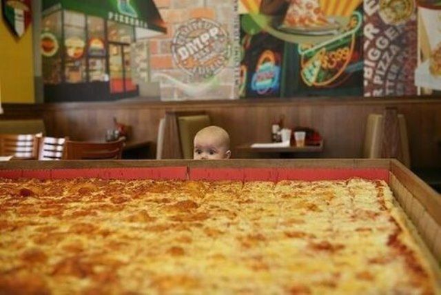 Малыш возле огромной пиццы