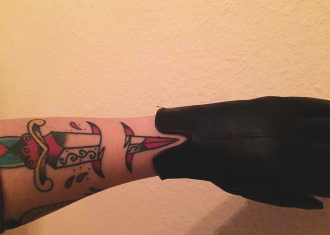 Рука с татуировкой в перчатке