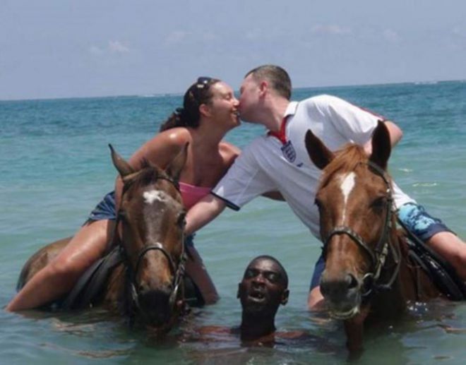 Пара на лошадях и афроамериканец в воде