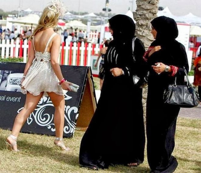 Женщины в хиджабах смотрят на девушку в мини платье