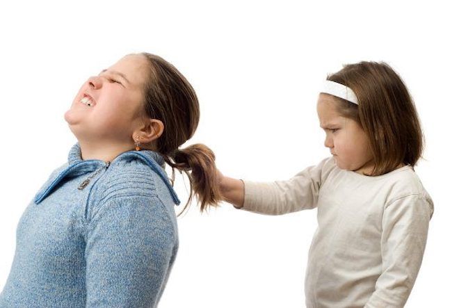 Одна девочка дергает другую за волосы