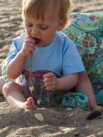Ребенок ест песок